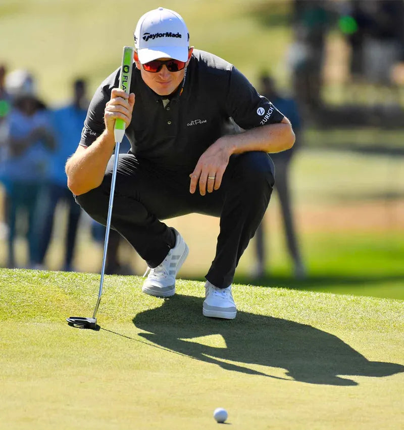 Justin Rose - a Capto user - crouching down reading a green